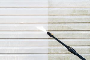 a before and after image of a home's siding being pressure washed